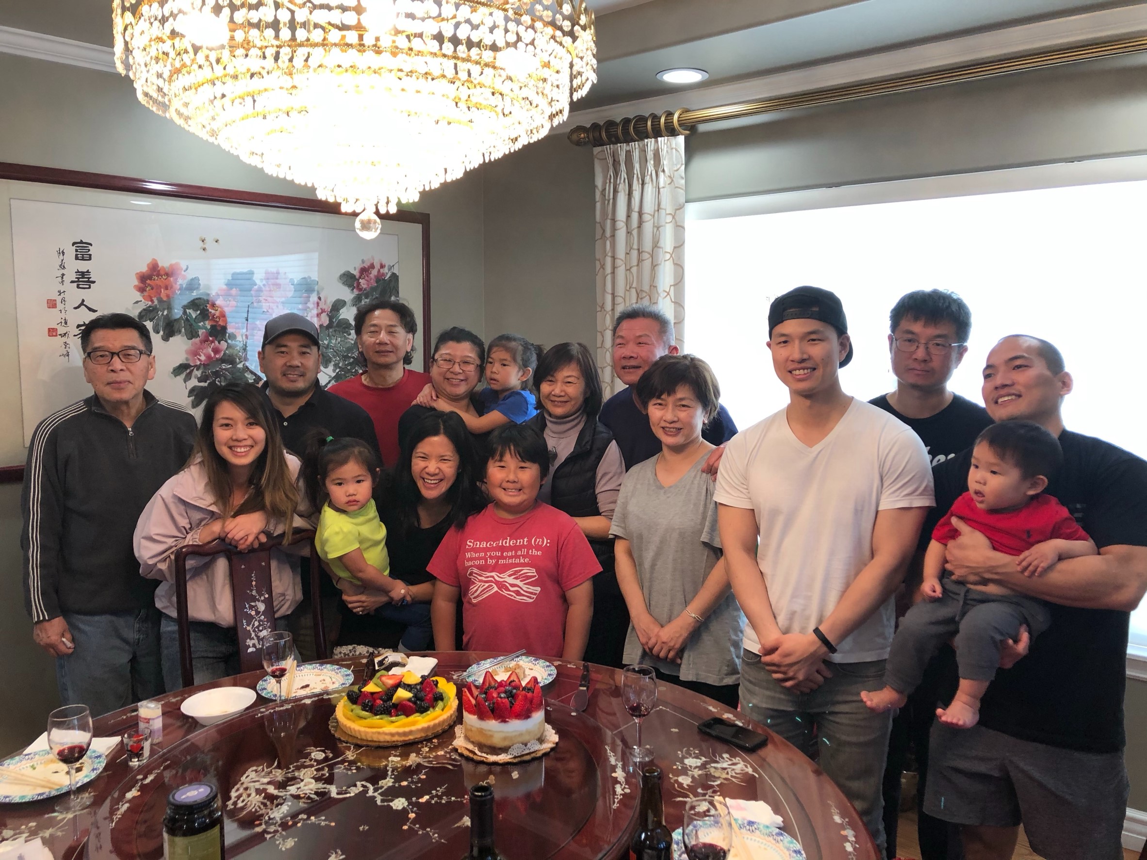 Large Asian American family of many generations stands around table full of food