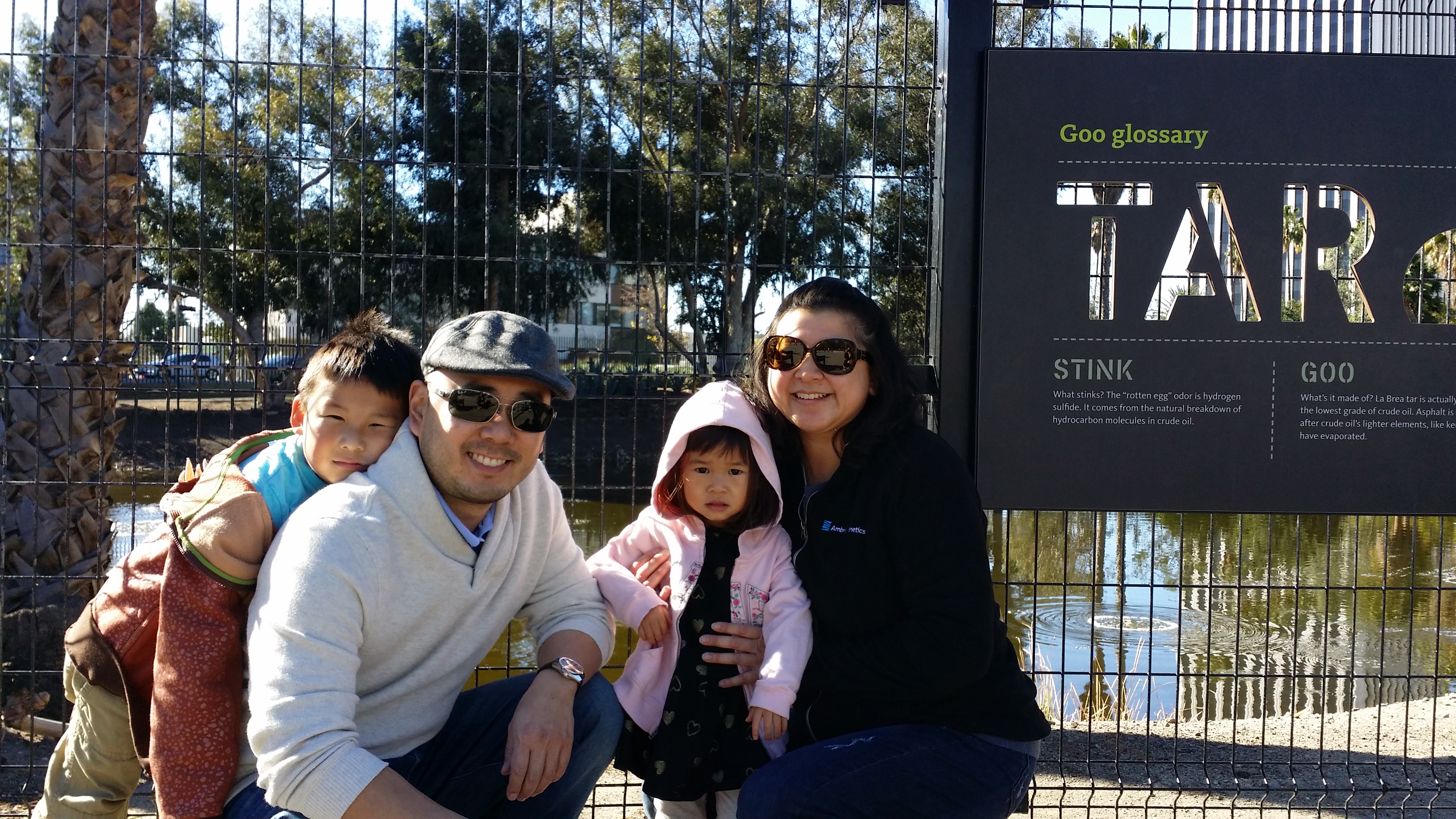 Chia-Ling Gau and husband, crouched and smiling with their two kids